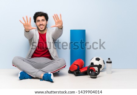 Sport man sitting on the floor counting ten with fingers