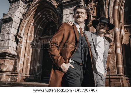 Two fashion young men walking on city street. Wearing in stylish casual and classic clothes with trendy hairstyle Royalty-Free Stock Photo #1439907407