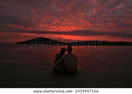 Cloud formations painted by the last rays of th setting sun can be gorgeous. I took this picture from the beach at Kleinbrak in South Africa.A loving couple enjoy it.