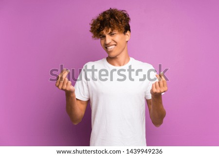 Young african american man over isolated purple wall making money gesture