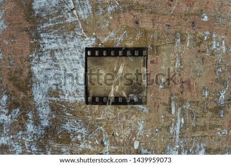 old 35mm filmstrip or snip with sellotape on old wall background