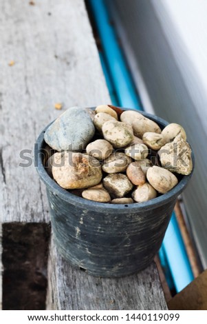 Rocks in pot on wooden in garden.
