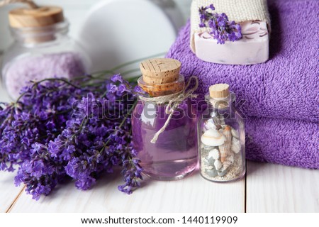Lavender flowers, lavender soap, aromatic sea salt and towels. Concept for spa, beauty and health salon, cosmetics store. Close up photo on white wooden background.