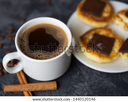 A Cup of fragrant espresso coffee and cheesecakes with chocolate and cinnamon