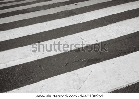 The white stripes were painted on black asphalt to mark the pedestrian crossing point.