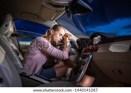 Young female driver at the wheel of her car, super tired, falling asleep while driving in a potentially dangerous situation - Road safety concept Royalty-Free Stock Photo #1440141287