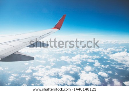 Close up of  an airplane wing while flying above white cloud against the sun light. Traveling concept with copy space for your text .

