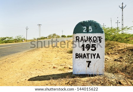 Horizontal color landscape of the 195 kilometers to Rajkot milestone on the Gujarat State Highway which runs through one of the most barren regions of India Royalty-Free Stock Photo #144015622