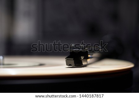 Turntable plays colored vinyl record in abstract background