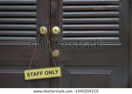 staff only sign tag hang on a wooden door