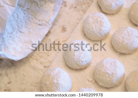 concept of baking bread. round soft dough for baking. board with cheesecakes and sprinkled flour. bag of white flour. soft focus.