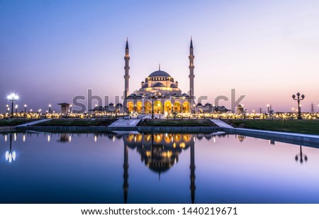 Largest Mosque in Sharjah beautiful traditional Islamic architecture new tourist attraction in Middle East Colorful evening shot of New Sharjah Mosque, Dubai Travel and Tourism Concept Image Royalty-Free Stock Photo #1440219671