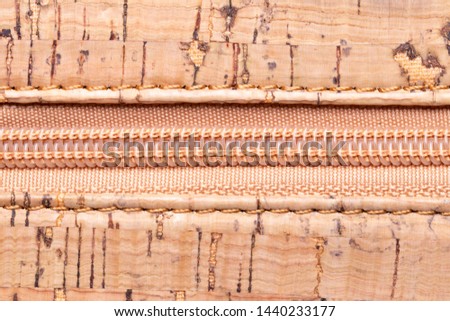 Close up of zipper. Closeup of a detail from a closed plastic zipper on a handbag made of natural cork. Macro.