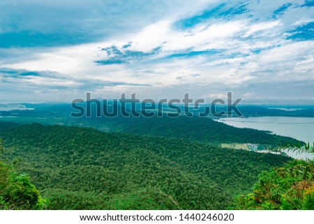Aerial view of Langkawi island's forest, mountains and coastal areas with blue sky background