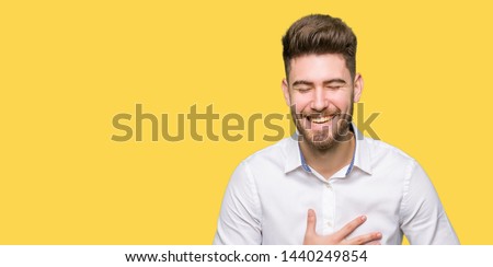 Young handsome business man Smiling and laughing hard out loud because funny crazy joke. Happy expression.