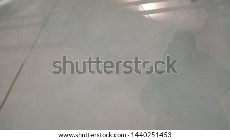 Shadow on a concrete floor of a person taking picture of an old airplane