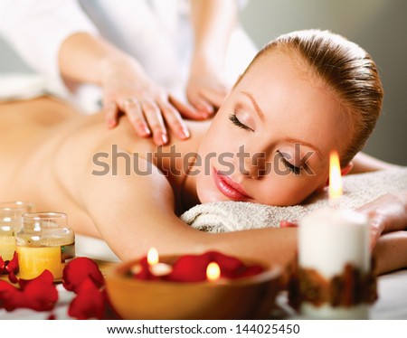 Beautiful young woman getting spa massage Royalty-Free Stock Photo #144025450
