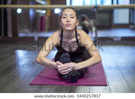 Young asian girl in fitness gym. young woman doing stretching