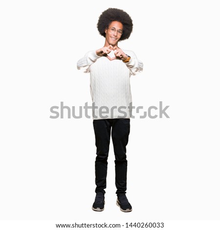 Young african american man with afro hair wearing glasses smiling in love showing heart symbol and shape with hands. Romantic concept.