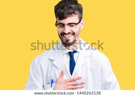 Young professional scientist man wearing white coat over isolated background Smiling and laughing hard out loud because funny crazy joke. Happy expression.