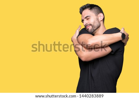 Young handsome man over isolated background Hugging oneself happy and positive, smiling confident. Self love and self care Royalty-Free Stock Photo #1440283889
