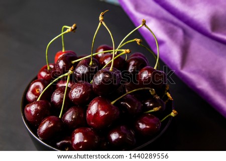 cherries in black containers on the table