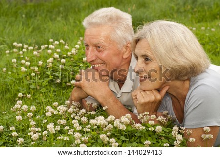 Nice old couple in the middle of the lawn with white flowers