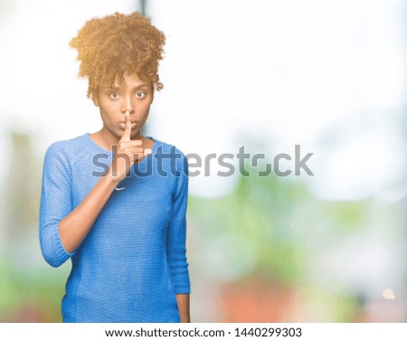 Beautiful young african american woman over isolated background asking to be quiet with finger on lips. Silence and secret concept.