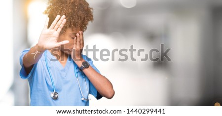 Young african american doctor woman over isolated background covering eyes with hands and doing stop gesture with sad and fear expression. Embarrassed and negative concept.