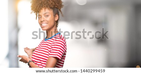 Beautiful young african american woman over isolated background Inviting to enter smiling natural with open hand