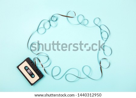 Analogue cassette tape on pastel blue background, 80s retro frame, lot of empty copy space. 