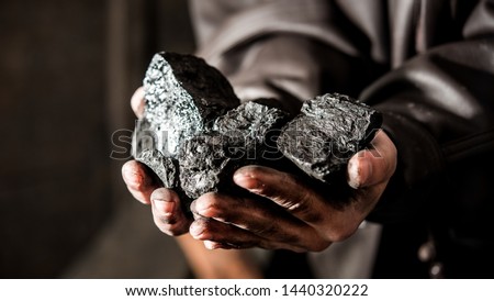 Coal mining : coal miner in the man hands of coal background. Picture idea about coal mining or energy source, environment protection. Industrial coals holding on hands. Volcanic rock. Panorama photo