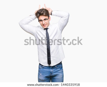Young business man wearing glasses over isolated background Posing funny and crazy with fingers on head as bunny ears, smiling cheerful