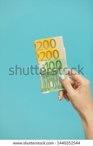 Female hands holding euro banknotes on a blue background. Euro Money. euro cash background
