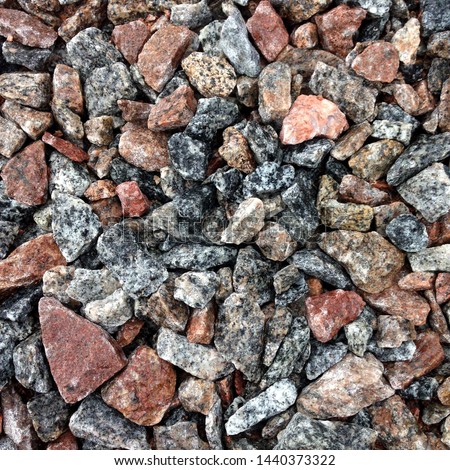 Macro photo of crushed stone and gravel on the ground. Texture background brown  stones on a black earth background. Image of broken stones and gravel