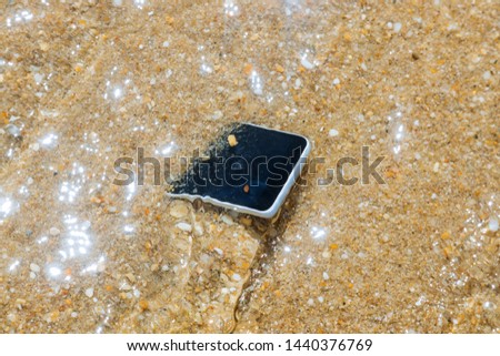 unknown woman has dropped her phone into the water of sea background