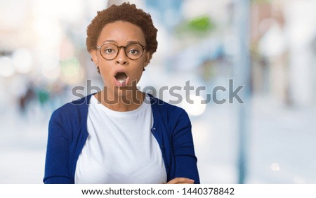 Young beautiful african american woman wearing glasses over isolated background afraid and shocked with surprise expression, fear and excited face.