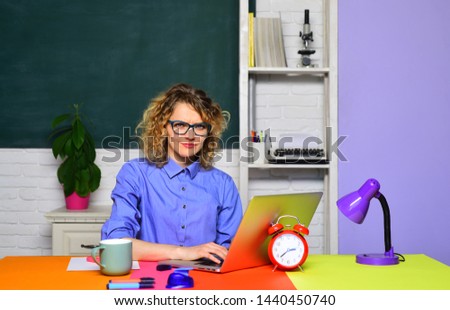 Teacher works with laptop in classroom. Female university student. Student preparing for test or exam. Teachers day. Teacher job. Profession and learning. High school concept. Education and knowledge.