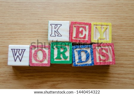 Educational toy cubes with letters organised to display word KEYWORDS - editing metadata and Search engine optimisation concept.