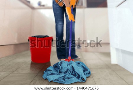 Women using a mop to clean the kitchen floor 