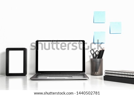 Digital technology Laptop with blank screen and book,picture frame on white table of wood ,Home interior or office background