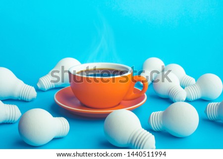 Idea and creativity concepts with hot coffee cup and light bulb on blue background.refreshment concepts Royalty-Free Stock Photo #1440511994