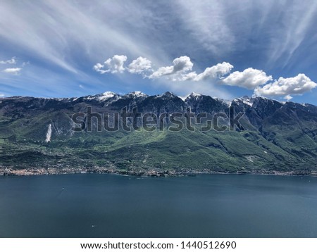 Beautiful view of Garda lake Italy. Mountains with snow. Sky with clouds. Pc screensaver