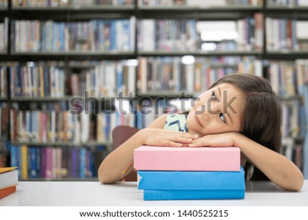 Adorable school girl sitting on the table and relax after reading box in the casual suit. Education library thinking out, Copy Space.