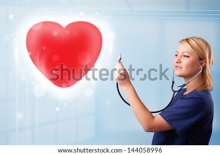 Pretty young nurse healing a red heart