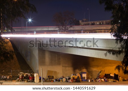 A homeless encampment under a Downtown Los Angeles freeway. Royalty-Free Stock Photo #1440591629