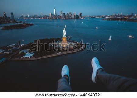 New york and Manhattan view from the helicopter . Man watching the city from the sky. Making a tour on a doors off helicopter to central park,financial district and statue of liberty