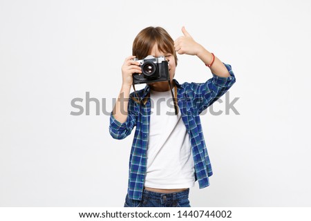 Fun little kid boy in blue t-shirt hold retro vintage photo camera, doing photo shot isolated on white wall background children studio portrait. People childhood lifestyle concept. Mock up copy space