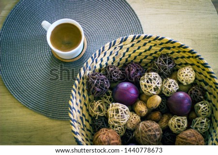 Cup of coffee on wooden board, with big knitted bowl. Love coffee concept. Black turkish coffee in white cup on wooden table. Close-up.
