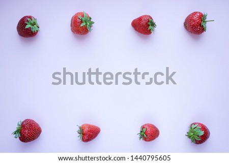 Frame of strawberry berries on a pink background, top view	